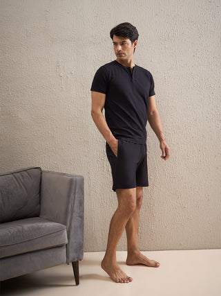 a men standing wearing a black gentlemen solid shorts set made of cotton modal spandex