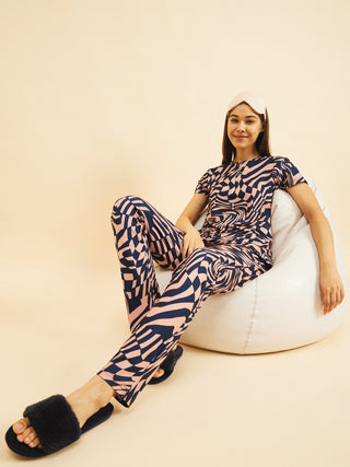 a women setting on a couch wearing a navy chic pyjama set made of cloud soft