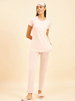 a women standing wearing pink salt fondle pyjama set made of cotton spandex