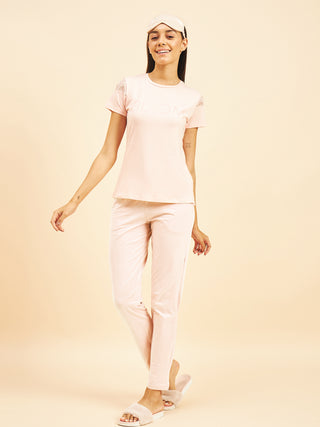 a women standing wearing pink salt fondle pyjama set made of cotton spandex