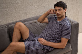 a men leaning on coach wearing printed shorts set on made of cotton modal aop